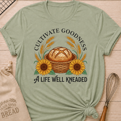 Sage Cultivate Goodness, A Life Well Kneaded women's relaxed fit tee with a rustic bread basket, golden wheat, and cheerful sunflowers