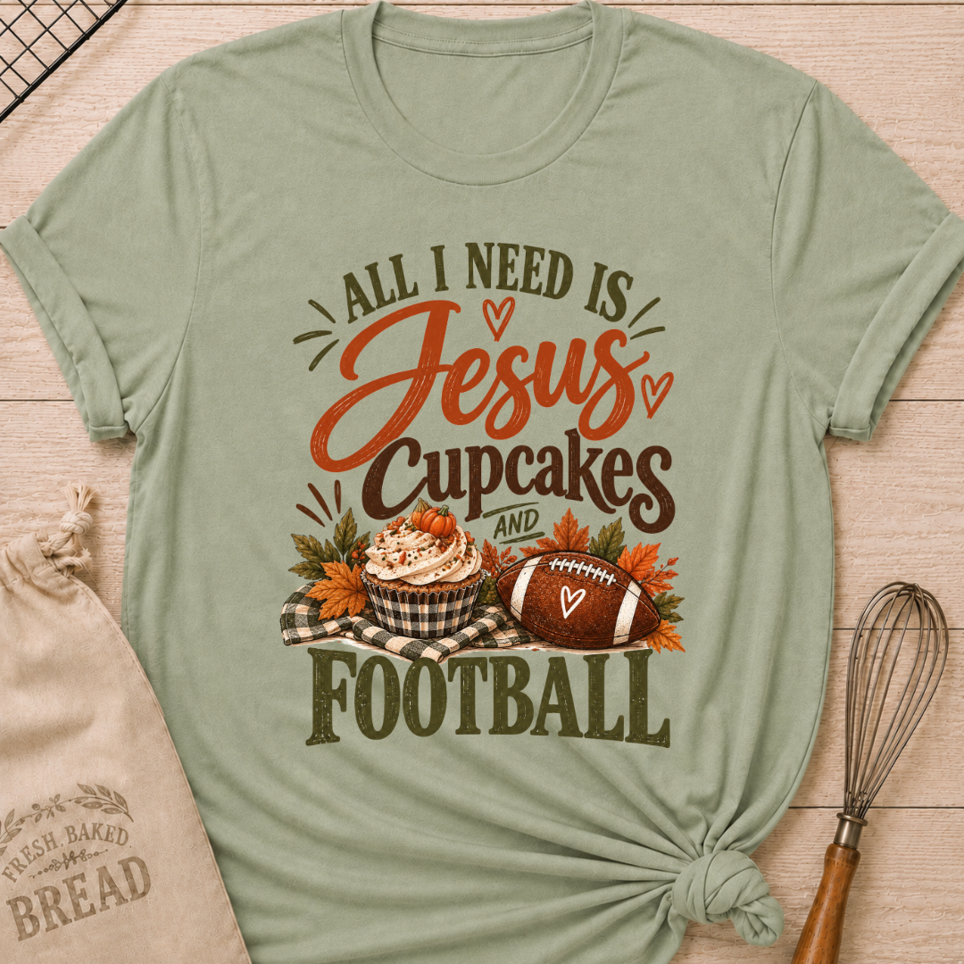 Sage women's relaxed fit tee with bold vintage All I Need Is Jesus, Cupcakes and Football lettering, a pumpkin topped cupcake, autumn leaves and a football on a gingham blanket