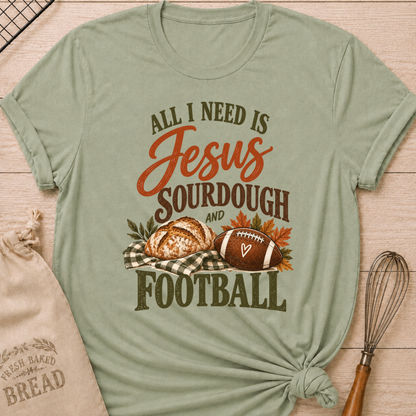 Sage women's relaxed fit tee with bold vintage All I Need Is Jesus, Sourdough and Football lettering, a rustic sourdough loaf, classic football, gingham accents and autumn leaves in rich harvest tones