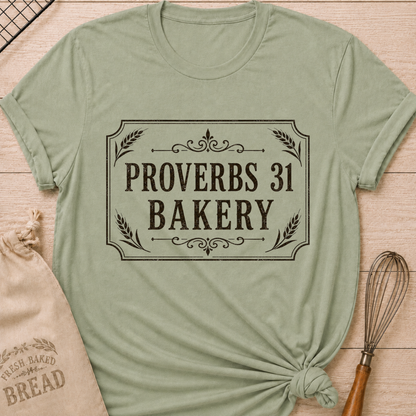 Sage green women's relaxed fit t-shirt with Proverbs 31 Bakery in classic lettering framed by wheat and ornamental details.