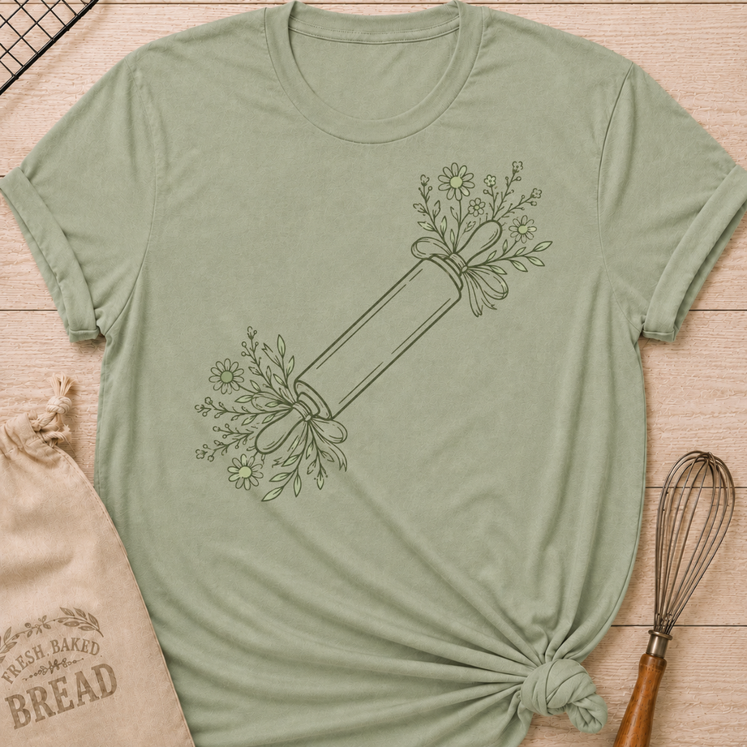 Sage green women's relaxed fit t-shirt with a rolling pin dressed in soft floral sprigs and bows.