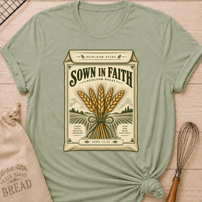 Sage women's relaxed fit tee with a vintage heirloom seed packet design, golden wheat, rolling fields and John 12:24 woven into the artwork beneath Sown in Faith lettering