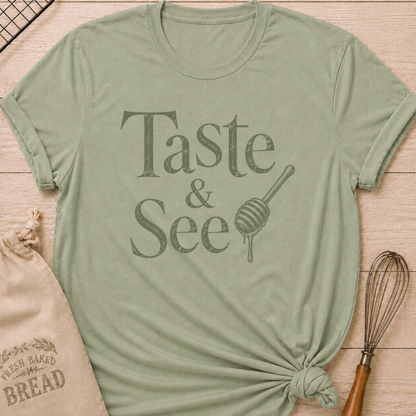 Sage green women's relaxed fit t-shirt with the words Taste and See in vintage lettering and a dripping honey dipper.