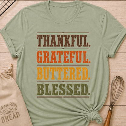 Sage women's relaxed fit tee with bold distressed Thankful Grateful Buttered Blessed lettering stacked in warm harvest brown, orange, gold and olive
