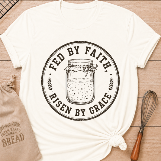 Vintage white women's relaxed fit t-shirt with a vintage sourdough starter jar, wheat and the words Fed by Faith, Risen by Grace.