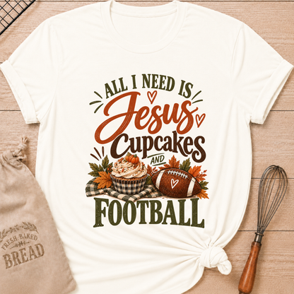 Vintage White women's relaxed fit tee with bold vintage All I Need Is Jesus, Cupcakes and Football lettering, a pumpkin topped cupcake, autumn leaves and a football on a gingham blanket