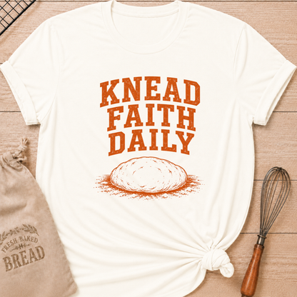Vintage white women's relaxed fit t-shirt with the words Knead Faith Daily in strong vintage lettering with a simple hand-drawn loaf in a classic bake shop style.