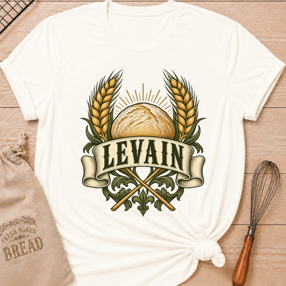 Vintage White women's relaxed fit tee with a rustic loaf between golden wheat and radiant accents, with Levain lettering on an old-world banner
