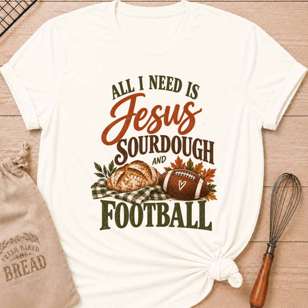 Vintage White women's relaxed fit tee with bold vintage All I Need Is Jesus, Sourdough and Football lettering, a rustic sourdough loaf, classic football, gingham accents and autumn leaves in rich harvest tones