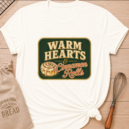 Vintage white women's relaxed fit t-shirt with the words Warm Hearts & Cinnamon Rolls in bold vintage lettering with a gooey iced cinnamon roll in a retro sign style.