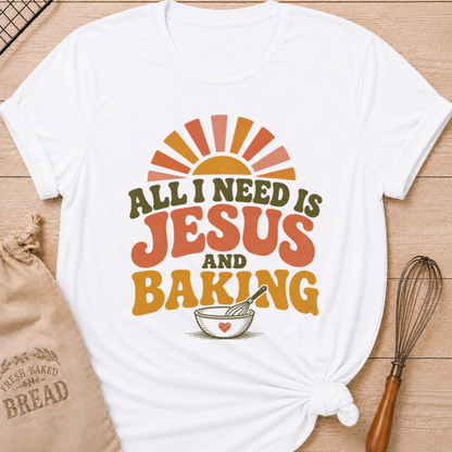 White All I Need Is Jesus and Baking women's relaxed fit tee with bold retro lettering, a rising sun, mixing bowl, and whisk