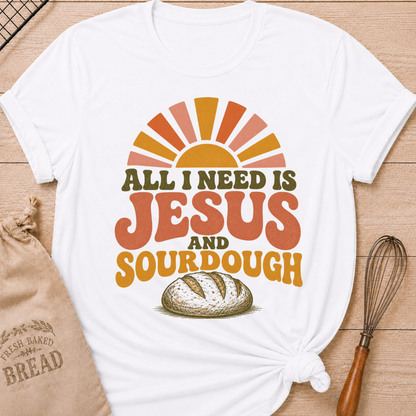 White All I Need Is Jesus and Sourdough women's relaxed fit tee with bold retro lettering, a rustic artisan loaf, and a sunrise