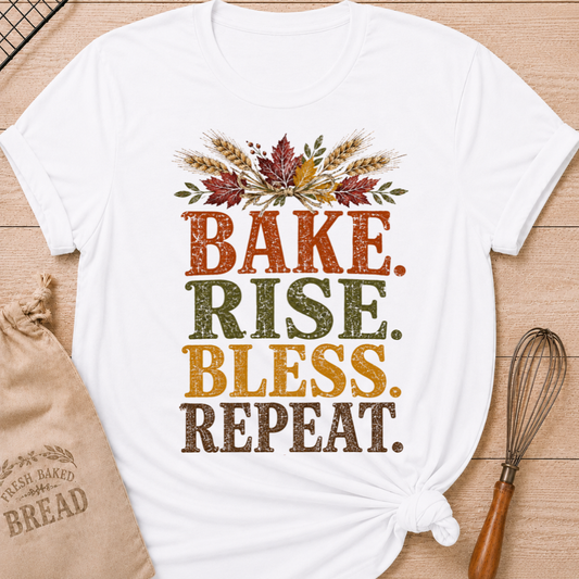 White women's relaxed fit tee with distressed vintage Bake Rise Bless Repeat lettering and a tied bundle of wheat and autumn leaves