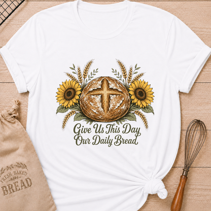 White women's relaxed fit tee with a rustic sourdough loaf, golden wheat, and yellow sunflowers, reading Give Us This Day Our Daily Bread