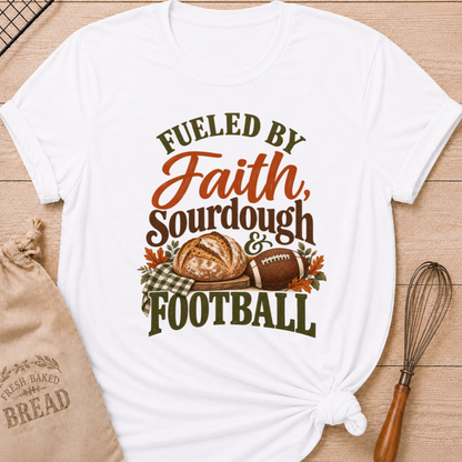 White women's relaxed fit tee with bold vintage Fueled by Faith Sourdough and Football lettering, a rustic sourdough loaf, classic football, gingham accents and autumn leaves