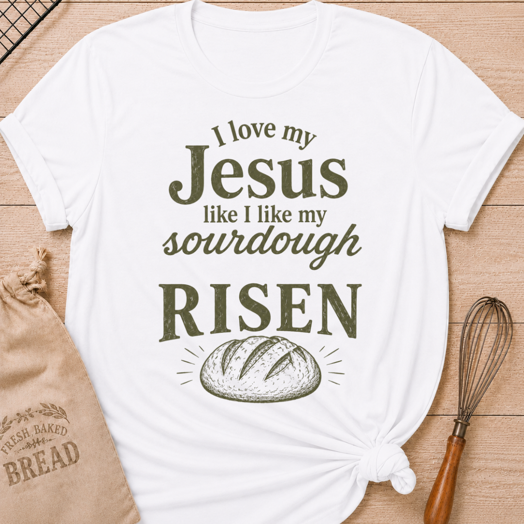 White women's relaxed fit t-shirt with the words I Love My Jesus Like I Like My Sourdough, Risen in bold vintage lettering and a rustic loaf of bread.
