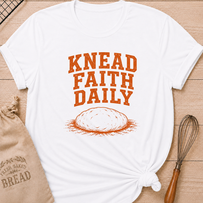 White women's relaxed fit t-shirt with the words Knead Faith Daily in strong vintage lettering with a simple hand-drawn loaf in a classic bake shop style.