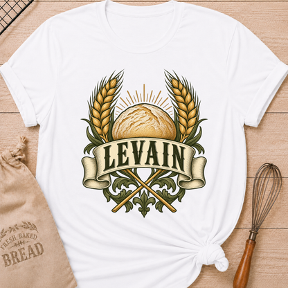White women's relaxed fit tee with a rustic loaf between golden wheat and radiant accents, with Levain lettering on an old-world banner