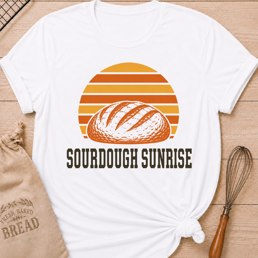 White women's relaxed fit t-shirt with a hand-scored sourdough loaf and a bold retro sunrise in rich harvest colors.