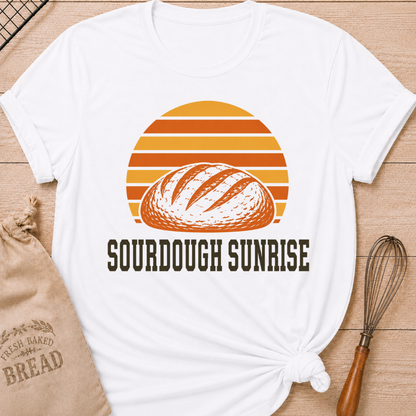 White women's relaxed fit t-shirt with a hand-scored sourdough loaf and a bold retro sunrise in rich harvest colors.