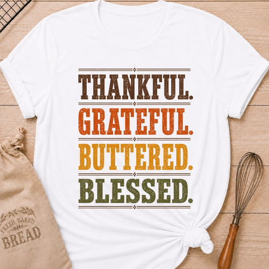 White women's relaxed fit tee with bold distressed Thankful Grateful Buttered Blessed lettering stacked in warm harvest brown, orange, gold and olive